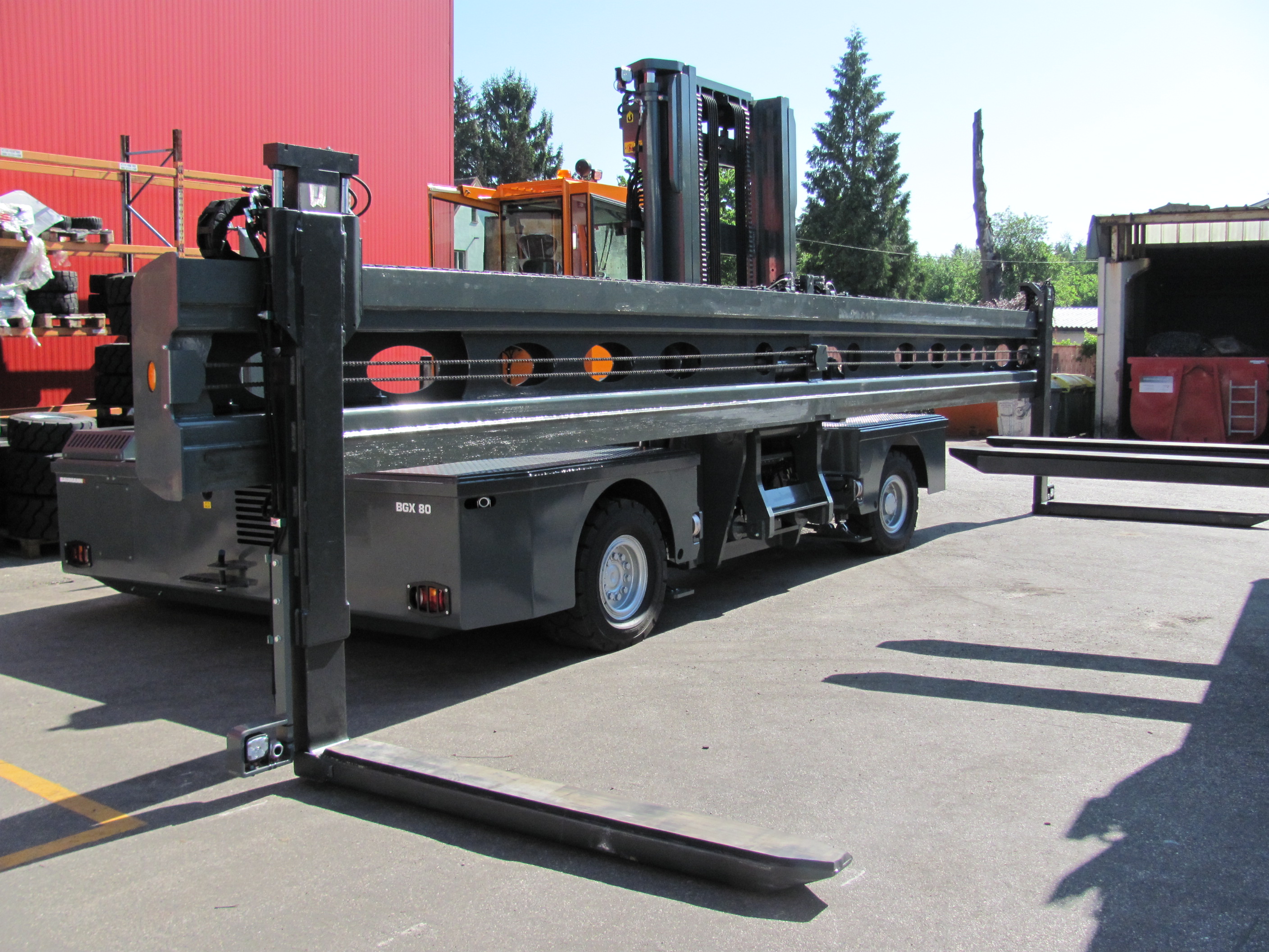 Single forklift fork equipment so-called height shift system for handling long goods to keep the goods horizontally during transport.